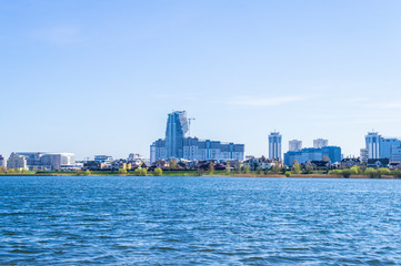 Fototapeta premium Beautiful urban lake with buildings and skyscrapers on the horizon