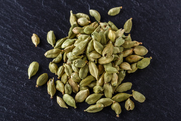 fragrant green cardamom on a dark stone background