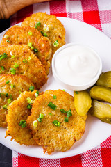 Delicious crispy potato pancakes on dark stone background