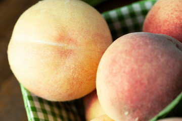 Fresh peaches in a basket close-up.