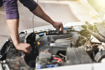 Man master repairs under the hood of the car