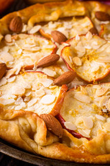 crispy apple galette with almonds on rustic wooden background