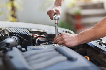 Man master repairs under the hood of the car