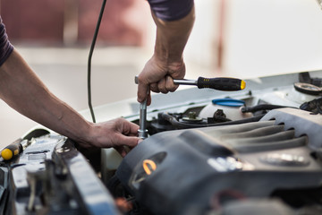 Man master repairs under the hood of the car