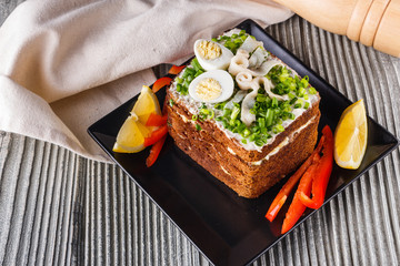 a huge herring sandwich with mayonnaise and quail eggs