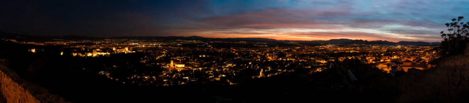 Aerial view of the sunset of Granada and the Alhambra. The sunset in Granada with the orange and blue tones of the sky.