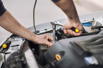Man master repairs under the hood of the car
