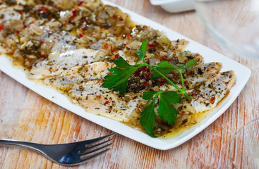 Spicy marinated herring fillet on a plate