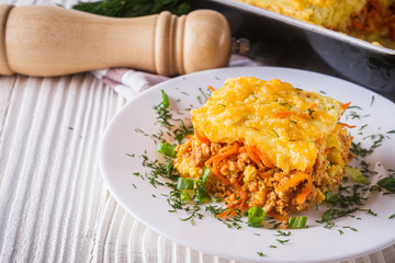 Delicious potato casserole with meat and cheese on a white wooden background