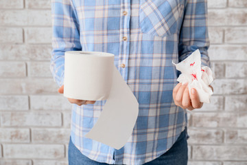 Woman holding toilet paper with blood spots. Hemorrhoids concept