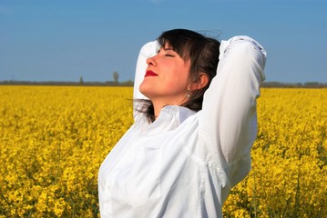 a woman in the yellow field under the sun