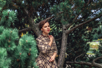 Naklejka premium a beautiful Turgenev Russian girl walks through an autumn park and read a book by Russian writer Dostoevsky's Crime and Punishment