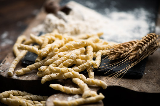 Raw pasta busiate on wooden table