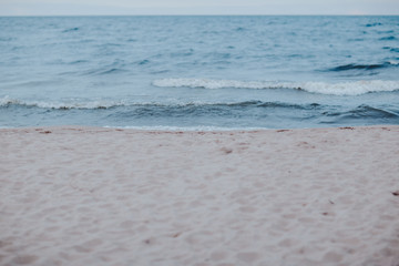 Sea coast with blue water. Stormy weather on the lake. Sandy beach with waves in bad weather. Nothern sea in wind.