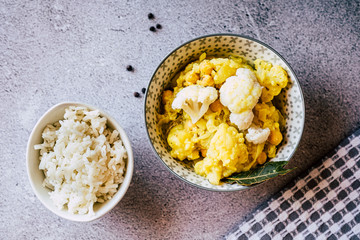 Curry de légumes avec des patates chou-fleur et pois chiche avec un bol de riz