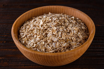 raw oatmeal on a wooden rustic background