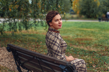 a beautiful Turgenev Russian girl walks through an autumn park and read a book by Russian writer Dostoevsky's Crime and Punishment