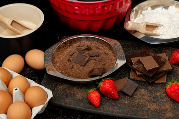 ingredients for homemade chocolate cake, grated chocolate, eggs, sugar, flour