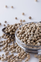 white peppercorns in glass bowl with spoon