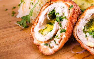 Fried cutlet cut in half on a wooden board