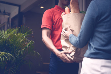 Delivery man send bag of vegetables and food to customers