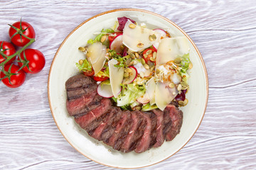 salad and sliced steak in a plate.