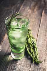 Sweet tequila based green cocktail with tarragon and rosemary. Selective focus. Shallow depth of...