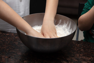 Close-up child`s hands preparing cookies