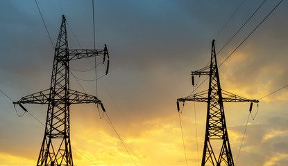 High-voltage power lines on sunset background