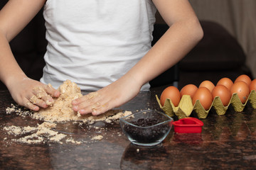 Close-up child`s hands preparing cookies