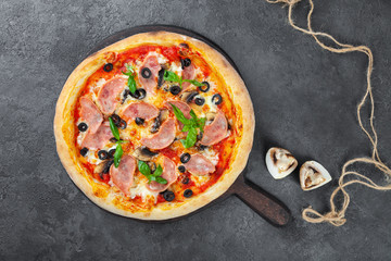 Meat pizza with carbonate, olives, mushrooms, tomatoes, basil, cheese
