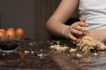 Close-up child`s hands preparing cookies