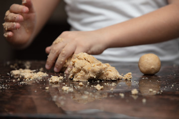 Close-up child`s hands preparing cookies