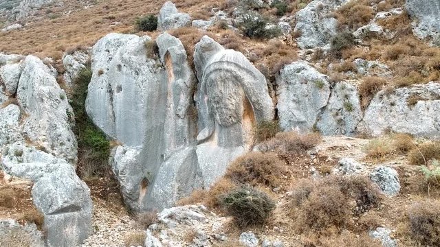 drone flight around the huge statue of charon engraved on a rock at st. pierre church location, antakya, turkey