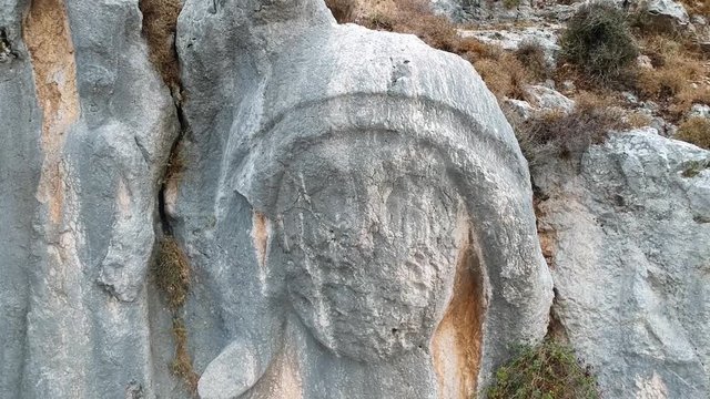 backwards flight from the huge statue of charon engraved on a rock at st. pierre church location, antakya, turkey