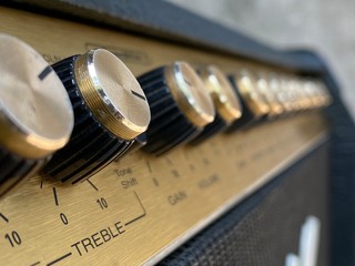 Close-up black knob, gold plate vintage combo amplifier.