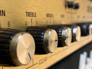 Close-up black knob, gold plate vintage combo amplifier.