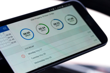 Electronic logging device for trucking industry with hours of service displayed on smarthphone...