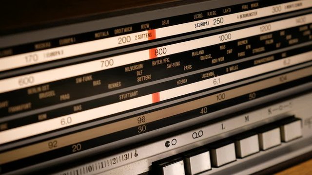 Tuning an old vintage analogic wooden radio dial. Close-up. Radio frequency receiver.