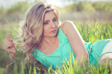 Naklejka na ściany i meble young blonde girl in a turquoise light dress