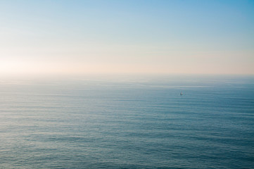 Obraz premium Widok bezkresu morza z żaglówką na Cabo da Roca, Sintra, Portugalia