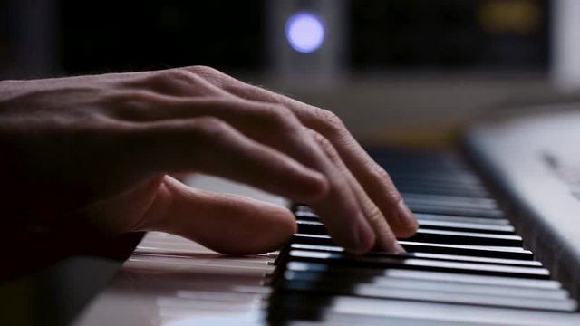 Creative music producer playing on the keyboard. Gig worker making music in the studio. Shot on RED in 4k. Free preview.
