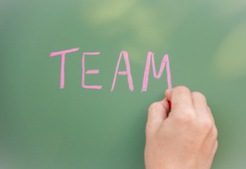 Selective focus, Word Team written on blackboard, Teamwork concept.