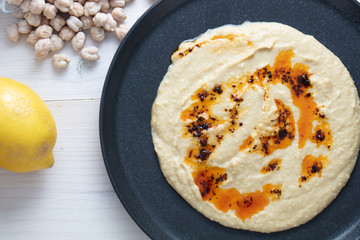 Delicious homemade hummus pasta with olive oil and chick-peas. Wooden table. Healthy food.