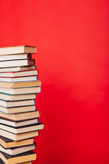 many stacks of educational books for college exams in the library on a red background