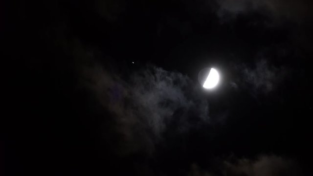vid&eacute;o en temps r&eacute;el d'un satellite passant devant la lune dans un ciel sans nuage