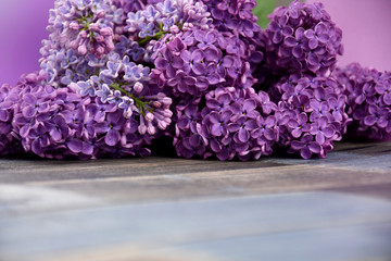 Lilac flower frame stock images. Beautiful blooming lilac flower border stock images. Bouquet of lilacs on the table images. Spring purple flowers on a wooden background with copy space for text