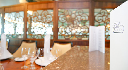 Close up view of formal dining table set up with glasses and white linen and menu in luxurious...