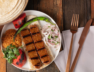 Turkish Adana Kebap With Rice Pilaf And Vegetables Served On A Plate