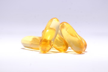 omega 3 fish oil capsule in golden color on white background 